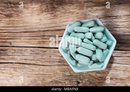 Les comprimés de spiruline sur fond de bois Banque D'Images