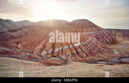 Vue aérienne de montagnes à rayures rouges de forme pyramidale au lever du soleil dans le parc du désert Altyn Emel au Kazakhstan Banque D'Images