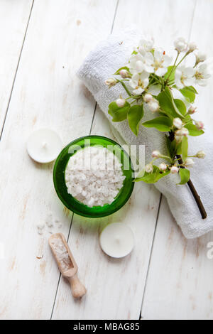 Belle composition de soins de spa sur table en bois blanc. L'huile de massage, serviette, sel de mer et des bougies Banque D'Images