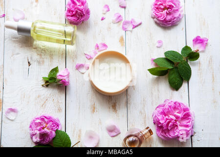 Crèmes cosmétiques et essence de rose l'huile avec des pétales de rose sur fond blanc d'un soin Spa. Spa Massage .vue supérieure mise à plat Banque D'Images