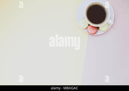 Télévision créative fixer photo de tasse à café et macarons avec copie espace sur fond jaune et rose style minimal Banque D'Images