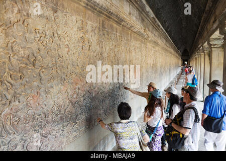 Les touristes à la recherche de sculptures sur pierre, temple d'Angkor Wat, temple hindou antique du 12ème siècle, site du patrimoine mondial de l'UNESCO, la Province de Siem Reap, Cambodge Asi Banque D'Images