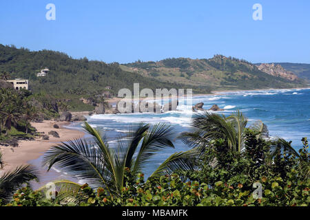 Vagues se brisant entre les roches avec plage de sable sur le rivage de la mer des Caraïbes Banque D'Images