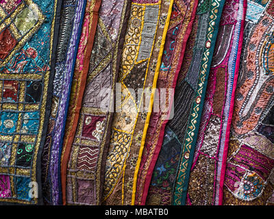 Tapisseries, des dynamiques se suspendre à un mur dans un souk de Marrakech au Maroc. Les tissus ont beaucoup de détails complexes. Banque D'Images