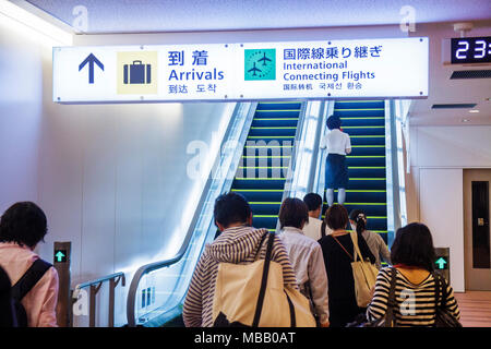 Tokyo Japon,aéroport Haneda,arrivées,passagers arrivant,escalier roulant,Anglais & Japonais,panneau,informations,directions,kanji,hiragana,caractères,symboles,Gat Banque D'Images