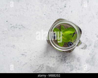 Vue du dessus de l'eau dans la région de chia pot Mason de menthe et de bleuet sur fond de ciment gris.Chia infusé avec des baies d'eau detox.Copy space for text.vue d'en haut. La saine alimentation, boissons, l'alimentation,concept detox Banque D'Images