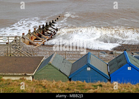 Vue du bord de mer à plus de cabanes de plage et de la promenade de la mer sur un fond gris d'avril à Sheringham, Norfolk, Angleterre, Royaume-Uni, Europe. Banque D'Images