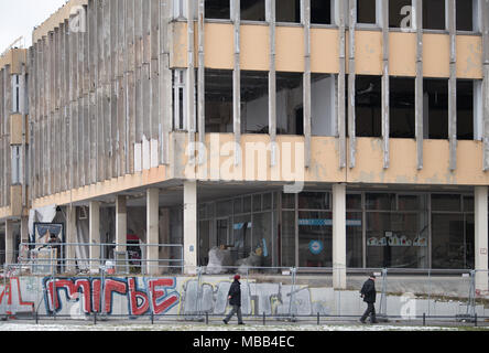 20 mars 2018, l'Allemagne, Potsdam : deux personnes âgées à pied passé le site de construction de l'ex-Fachhochschule Potsdam Université de Sciences Appliquées. Le bâtiment est censé être déchiré dorn en septembre 2018. Photo : Soeren Stache/dpa/ZB Banque D'Images