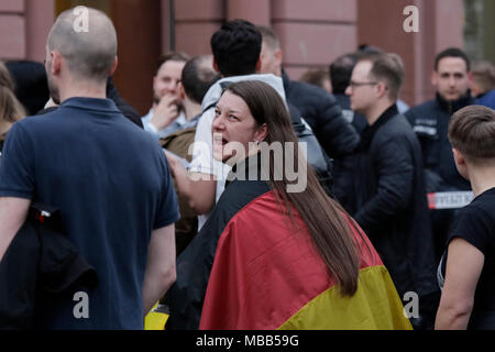 Mainz, Allemagne. 9 avril 2018. Un manifestant de droite porte un drapeau allemand sur ses épaules. Autour de 50 manifestants de droite se sont rassemblés dans le centre-ville de Mayence, pour protester contre le gouvernement allemand, pour la fermeture des frontières et contre les réfugiés sous le slogan d'goÕ ÔMerkel a. Ils étaient environ 400 chahuté par des contre-manifestants. Crédit : Michael Debets/Alamy Live News Banque D'Images