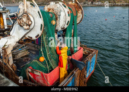 Schull, Irlande. 19 avril, 2018. Sur un froid, mais sec et venteux nuageux jour, deux pêcheurs préparent leurs filets avant de partir à la pêche. Il y aura des averses ce soir cette nuit avec les bas de 6°. Credit : Andy Gibson/Alamy Live News. Banque D'Images