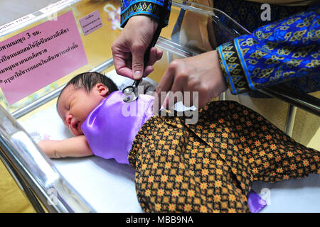 (180410) -- BANGKOK, 10 avril 2018 (Xinhua) -- Un médecin n'health check pour un bébé nouveau-né habillé en costume traditionnel thaïlandais avant le prochain Festival de Songkran, le Nouvel An thaï, dans un hôpital de Bangkok, Thaïlande, avril. 10, 2018. (Xinhua/Sageamsak Rachen) (zjl) Banque D'Images