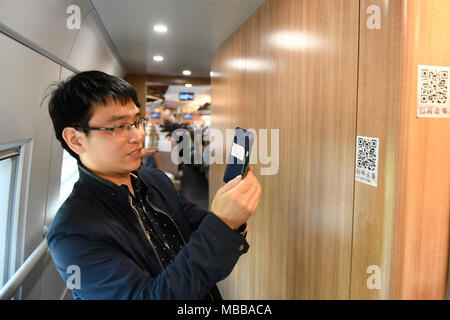 (180410) -- HANGZHOU, 10 avril 2018 (Xinhua) -- un passager avec l'alimentation des commandes sur un téléphone mobile de Hangzhou Hefang bullet train à Pékin, le 10 avril 2018. China Railway Corporation, le transporteur ferroviaire du pays, mis à jour son schéma de planification du service mardi. (Xinhua/Huang Zongzhi)(mcg) Banque D'Images