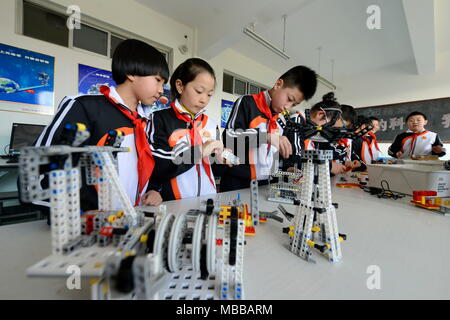 Tangshan, Province de Hebei en Chine. 10 avr, 2018. Les étudiants pratiquent l'assemblage du robot à l'école primaire de comté Laoting, Chine du nord, dans la province du Hebei, le 10 avril 2018. Les robots sont introduits dans les programmes éducatifs parascolaires à l'école. Credit : Mu Yu/Xinhua/Alamy Live News Banque D'Images