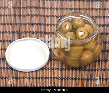 Main verte olives colossales farcies à l'gants in jar Banque D'Images