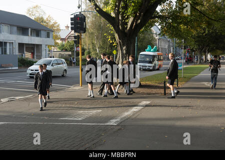 Des écoliers en uniforme en face de Christ's College, Christchurch, Nouvelle-Zélande Banque D'Images