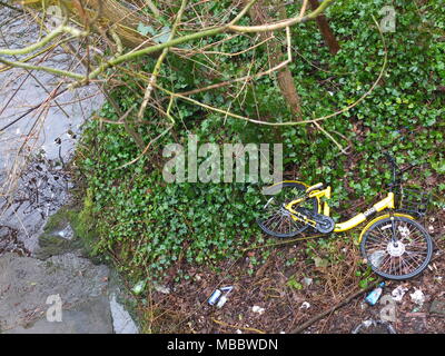 Un vélo de location Ofo jaune jeté jeté le pont sur la rivière de banques, Rivelin Sheffield. La hire scheme a été par la suite retiré de la ville. Banque D'Images