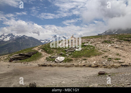 Alors que les drapeaux de prières flottent dans de forts vents crossing Rohtang, moutons et chèvres à pied à travers la scène. Aujourd'hui, les vents sont maintenant loin des pluies de mousson Banque D'Images