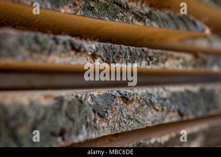 En bois plié brun et gris bandes dans une scierie. D' aulne empilés comme texture. Banque D'Images