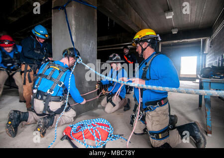 Les pompiers du Groupe de travail du Mississippi, de l'équipe de recherche et sauvetage en milieu urbain à sécuriser un système de cordes pour permettre leur coéquipier's s'échapper d'un bâtiment effondré simulé au cours de l'exercice de formation Sud 18 PATRIOT, au camp Shelby, Mississippi, le 14 février 2018. PATRIOT Sud, une joint-agency l'exercice d'entraînement aux opérations, l'accent sur la préparation aux catastrophes naturelles pour non seulement des unités de la Garde nationale de partout au pays, mais aussi les premiers intervenants civils. (Ohio Air National Guard Banque D'Images