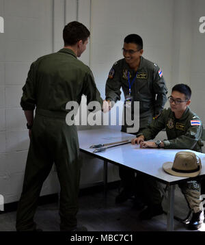 Royal Thai Air Force Le Chomngan Nitinan, centre, à partir de Bangkok, serre la main avec le capitaine de l'US Air Force Colton Steen après une brève mission 14 février 2018, à Korat Royal Thai Air Force Base, Royaume de Thaïlande, dans le cadre de l'exercice Gold Cobra en 2018. Chomngan est pilote de chasse avec le 403e Escadron de chasse, et Steen est un pilote de chasse avec le 36e Escadron de chasse. Le projet pilote sur la droite est la Royal Thai Air Force Le Capitaine Napaeakkapak Preadum de Takhli, est un pilote de chasse avec le 403e Escadron de chasse. Steen mémoires la mission et comment il devrait fonctionner alors que dans l'air en vue d'édification de l'équipe co Banque D'Images