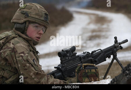 Un soldat britannique avec le Light Dragoons attend de recevoir des directives, comme il se prépare à ses feux 5,56 millimètres-light machine gun à une gamme près de la zone d'entraînement Bemowo Piskie, Pologne, le 15 février 2018. Ce soldat est une partie de l'unique groupe de combat multinationales, composé de États-Unis, Royaume-Uni, croate et soldats roumains qui servent avec la 15e Brigade mécanisée polonaise comme une force de dissuasion dans le nord-est de la Pologne à l'appui de l'OTAN vers l'amélioration de la présence. (U.S. Army Banque D'Images