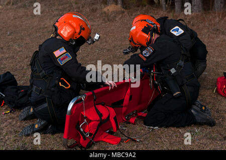 Les membres de l'hélicoptère de la Caroline du Sud l'équipe de Sauvetage Aquatique recueillir leurs engins après la simulation d'un sauvetage par hélicoptère sur la garde nationale de Caroline du Sud un UH-60 Black Hawk au cours de l'exercice 18 du patriote au camp Shelby, Mississippi, le 15 février 2018. Du Sud 2018 PATRIOT teste les capacités combinées de la Garde nationale, ainsi que des organismes d'État et locaux, de répondre lors de catastrophes naturelles à l'aide de simulation de scénarios d'urgence. (U.S. Air National Guard Banque D'Images