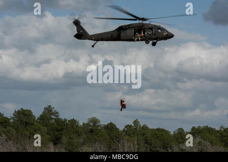 Kovalanchik Emerson, L.C. (équipe de sauvetage aquatique en hélicoptère, monte une victime simulée dans un UH-60 Black Hawk pendant la formation treuil de sauvetage en hélicoptère avec la Compagnie Alpha, 1-111ème bataillon de l'aviation de la Garde nationale, L.C. 2018, au cours de l'PATRIOT Camp Shelby, Hattiesburg, Mississippi, le 15 février 2018. PATRIOT est un exercice d'entraînement aux opérations domestiques parrainé par la Garde nationale qui vise à accroître la compréhension de la coordination, politiques et procédures nécessaires à la réalisation d'une réponse nationale interinstitutions. (U.S. Air National Guard Banque D'Images