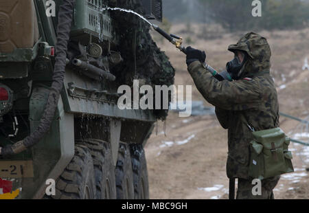 Un soldat polonais avec le 1er Bataillon, 15e Brigade mécanisée, procède à un lavage pour décontaminer un Stryker américain au cours de produit chimique, biologique, radiologique et nucléaire (CBRN) formation à une gamme près de la zone d'entraînement Bemowo Piskie, Pologne, 16 février 2018. Ce soldat est une partie de l'unique groupe de combat multinationales, composé de États-Unis, Royaume-Uni, croate et soldats roumains qui servent avec la 15e Brigade mécanisée polonaise comme une force de dissuasion dans le nord-est de la Pologne à l'appui de l'OTAN vers l'amélioration de la présence. (U.S. Army Banque D'Images
