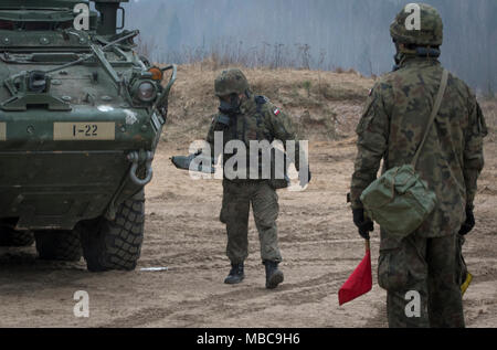 Un soldat polonais avec le 1er Bataillon, 15e Brigade mécanisée, utilise l'agent chimique Moniteur (CAM) pour vérifier la présence de contaminants sur un Stryker américain au cours de produit chimique, biologique, radiologique et nucléaire (CBRN) formation à une gamme près de la zone d'entraînement Bemowo Piskie, Pologne, 16 février 2018. Ces soldats sont une partie de l'unique groupe de combat multinationales, composé de États-Unis, Royaume-Uni, croate et soldats roumains qui servent avec la 15e Brigade mécanisée polonaise comme une force de dissuasion dans le nord-est de la Pologne à l'appui de l'OTAN vers l'amélioration de la présence. (U.S. Army Banque D'Images