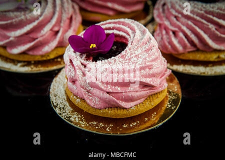 Rose gros plan zephyr cookie décoré de fleurs violettes sur fond miroir noir Banque D'Images