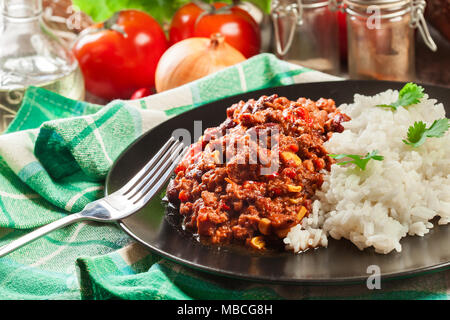 Hot chili con carne avec du boeuf haché, haricots, tomates et de maïs servi avec du riz. La cuisine mexicaine Banque D'Images