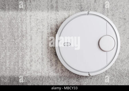 Aspirateur Robot travaillant sur un tapis top view concept Banque D'Images