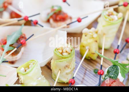 Rouleaux de courgettes avec les pignons de pin. Sauce Pesto. Table de buffet savoureux. Fête de l'été à l'extérieur. Banque D'Images