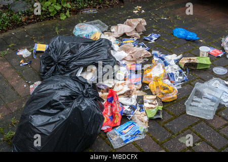 Sacs déchirés de déchets avec la litière éparpillés sur le chemin avant d'une maison à Londres Banque D'Images