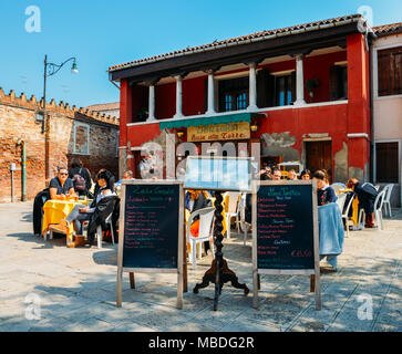 Les touristes sont assis à la terrasse d'un petit café à l'île de Murano, un jour ensoleillé Banque D'Images