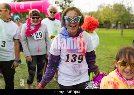 Portrait of smiling, ludique coureuse à silly lunettes de charity run dans park Banque D'Images