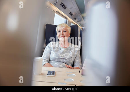 Souriant, confiant businesswoman on train de passagers Banque D'Images