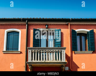 Mur orange de la chambre avec une fenêtre aux volets bleus et d'un balcon. Banque D'Images