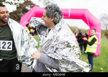 Male les coureurs de marathon, course de finition portant des couvertures thermiques Banque D'Images