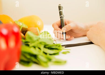 Plan de régime nutritionniste femme écrit sur le tableau plein de fruits et légumes Banque D'Images