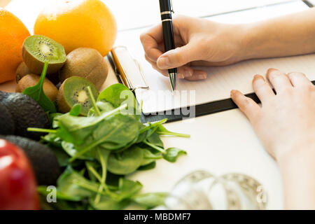 Plan de régime nutritionniste femme écrit sur le tableau plein de fruits et légumes Banque D'Images