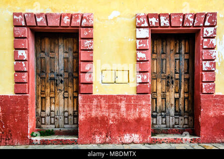 Portes en bois encadrée par des murs de briques rouges et jaunes en San Cristobal de las Casas, Chiapas, Mexique Banque D'Images