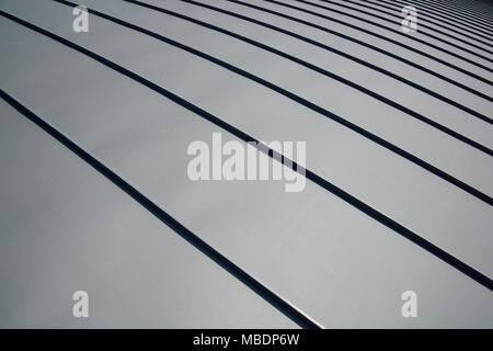 Le toit de zinc incurvée moderne du bâtiment. Le ruissellement des eaux de pluie en structure convexe gouttières zinc. Banque D'Images