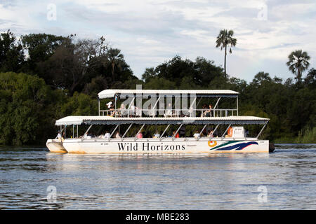 Horizons sauvages un bateau pendant une croisière au coucher du soleil sur le fleuve Zambèze, près de Victoria Falls au Zimbabwe. Banque D'Images