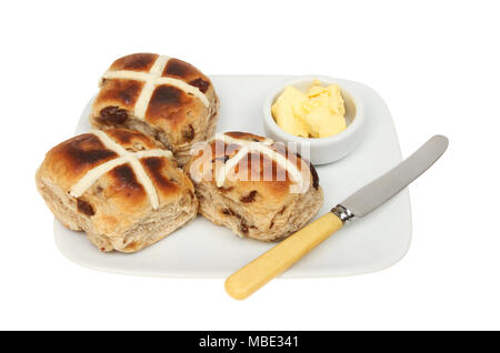 Les brioches grillées sur une plaque avec du beurre et un couteau à beurre blanc isolé contre Banque D'Images