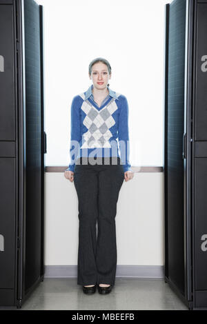 Caucasian woman Technicien de laboratoire à côté de racks dans une batterie de serveurs informatiques Banque D'Images