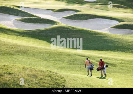 Vue de dessus de deux golfeurs marche sur une allée vers la greeen d'un terrain de golf. Banque D'Images