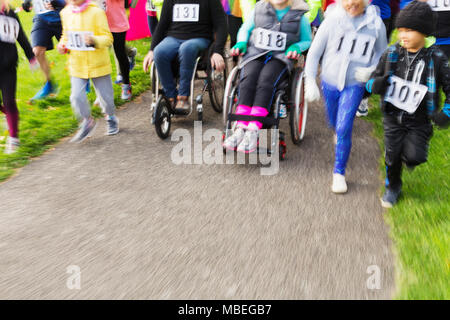 Les personnes en fauteuil roulant et glissières de déménagement de charity race Banque D'Images
