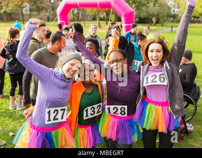 Portrait femme enthousiaste porteur en tutus cheering at charity run dans park Banque D'Images