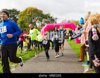 Porteur d'atteindre pour l'eau, tournant au charity run dans park Banque D'Images